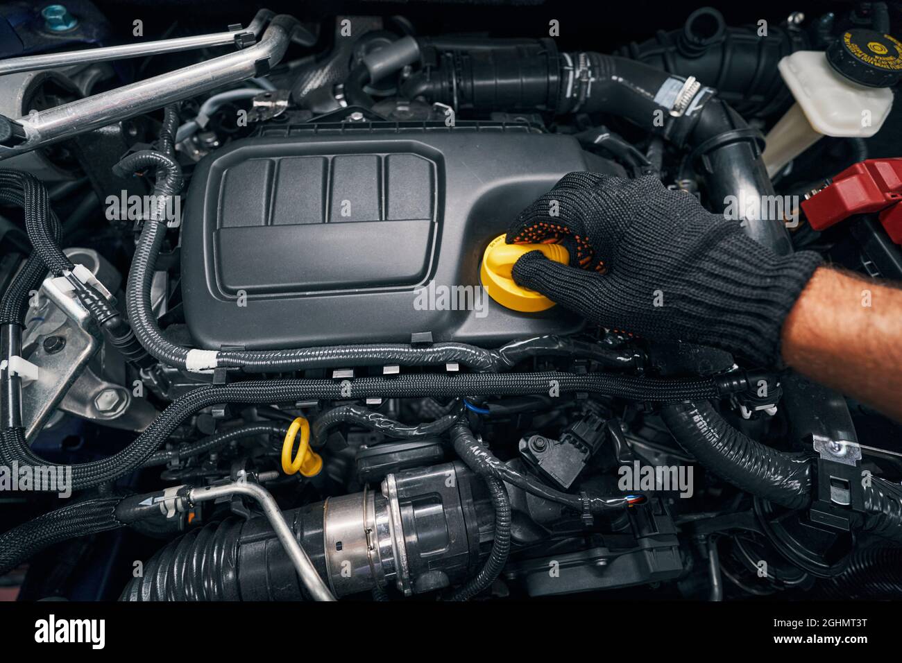 Worker removing oil filler cap of engine Stock Photo Alamy