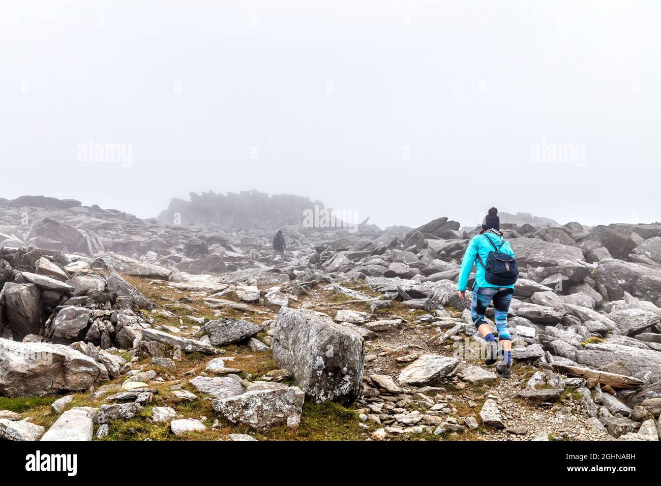 Hikers walking on rocky terrain along the trail to the Glyder Fawr summit, Cwm Idwal, Snowdonia, Wales, UK Stock Photo