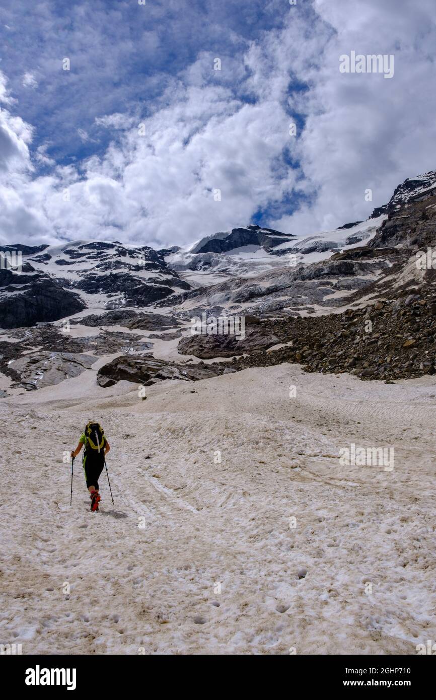 Woman with crampons and snow poles climbing a glacier in Mount Rosa range, Italian Alps Stock Photo