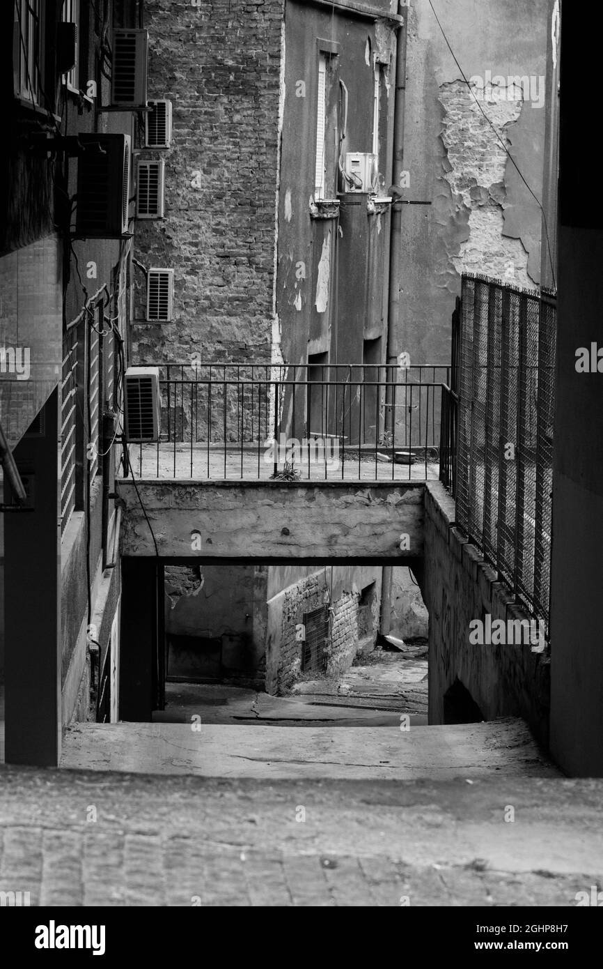 Destroyed old abandoned city alley in black and white Stock Photo