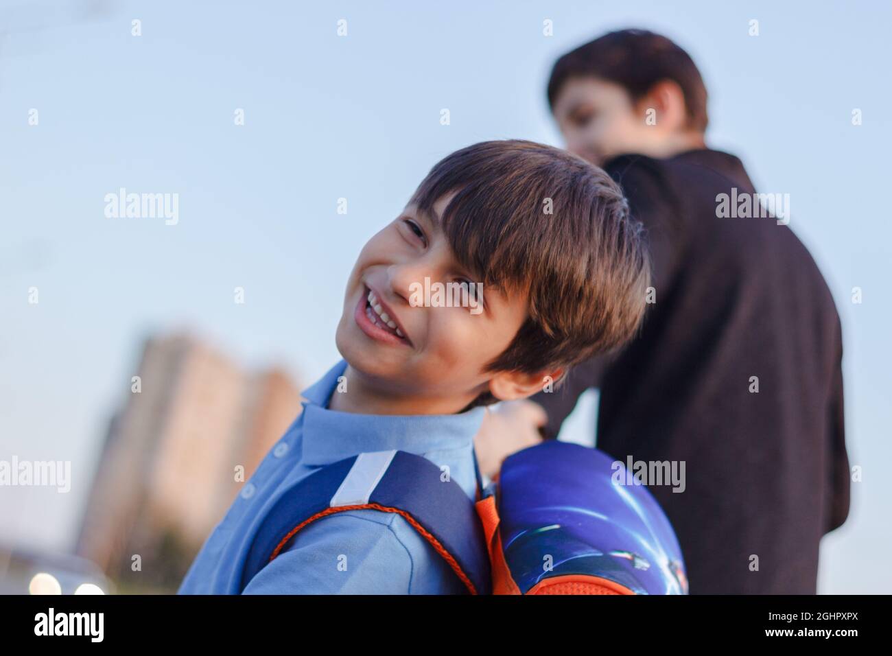 Brothers go to school. The teenager and his younger brother with backpacks hold hands, brothers smile happy faces of children. back to school Stock Photo