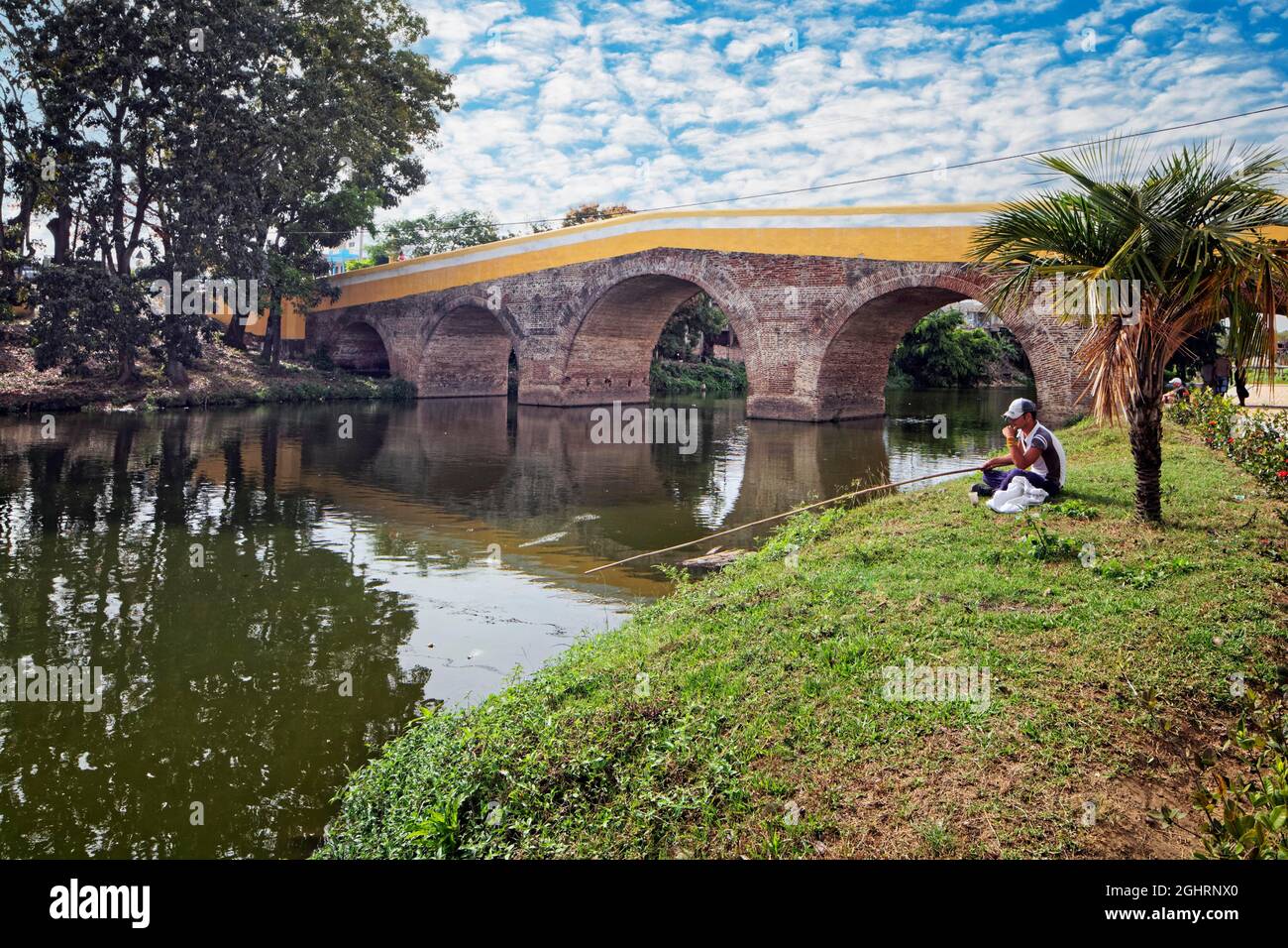 Angler, old bridge, stone bridge, Puente Yayabo, built 1817-1825, landmark, Yayabo River, Sancti Spiritus, Central Cuba, Sancti Spiritus Province Stock Photo
