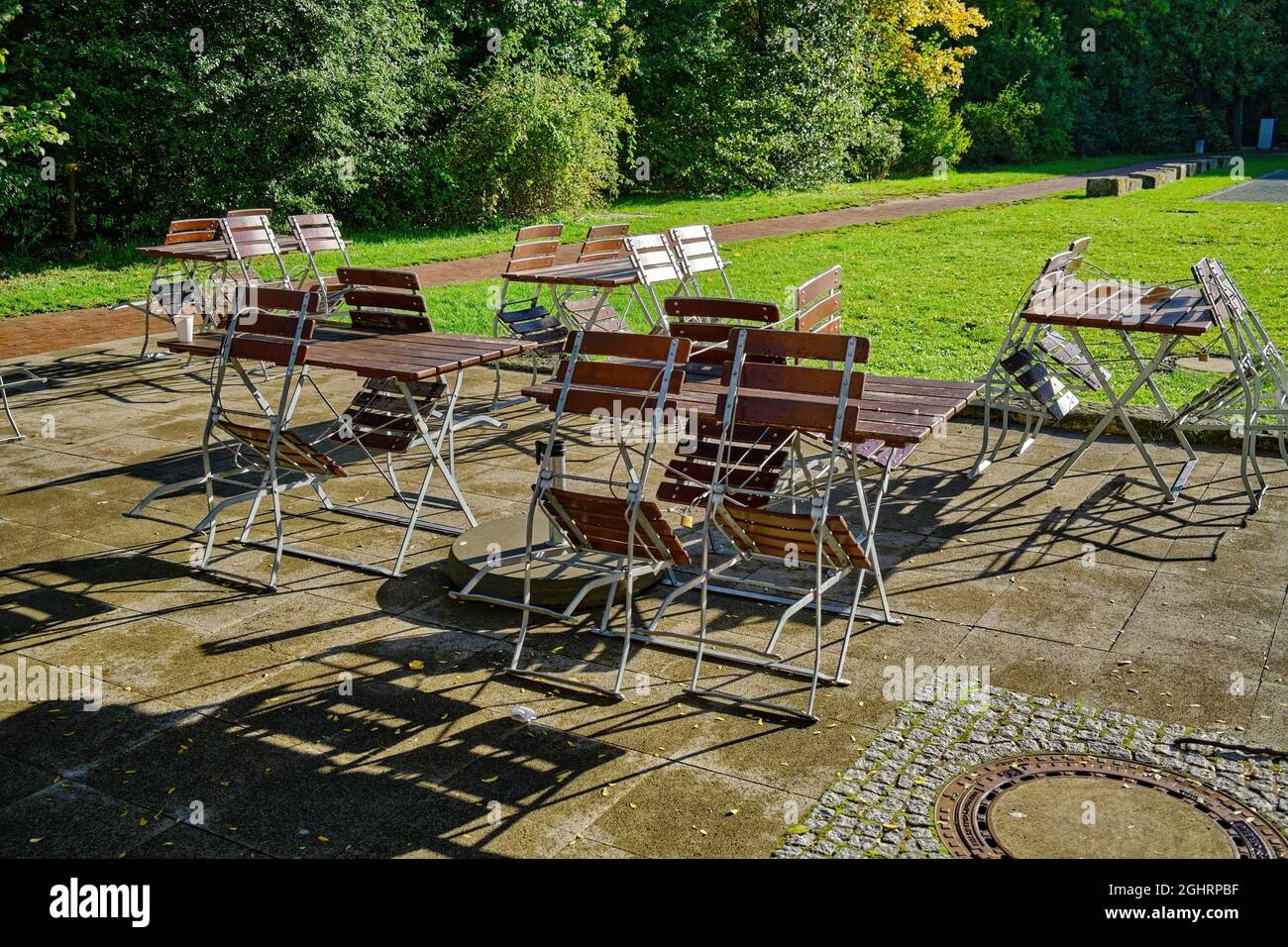 Stühle und Tische auf einer sonnigen Terrasse an der Leine in Limmer, Hannover-Limmer, Deutschland / Germany Stock Photo
