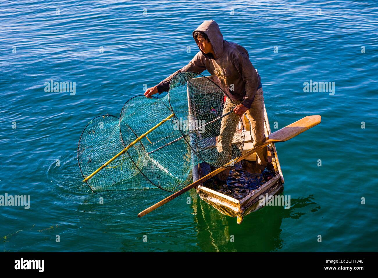 Fisherman with fish trap in his floating coffin, Eupithecia (Catarina) Palopo, Lake Atitlan, Santa Catarina Palopo, Guatemala Stock Photo