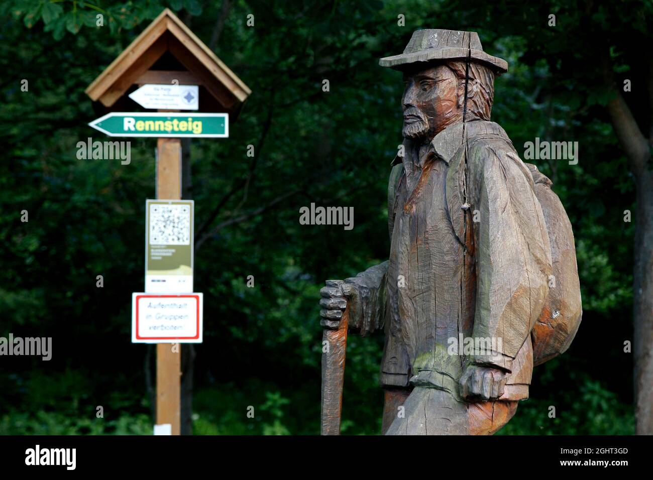 Wooden statue hiker with hat, sign Rennsteig, signpost to the Rennsteig, Rennsteig, high hiking trail, Thuringian Forest, Green Belt, border trail Stock Photo