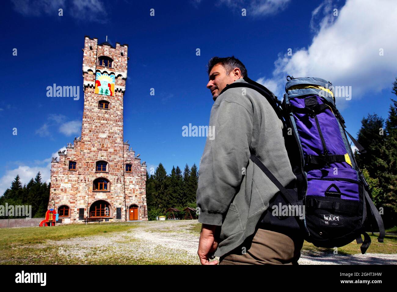 Man with backpack, hiker at the Altvaterturm on the Wetzstein, memorial against the expulsion of people, Rennsteig, high hiking trail, Thuringian Stock Photo