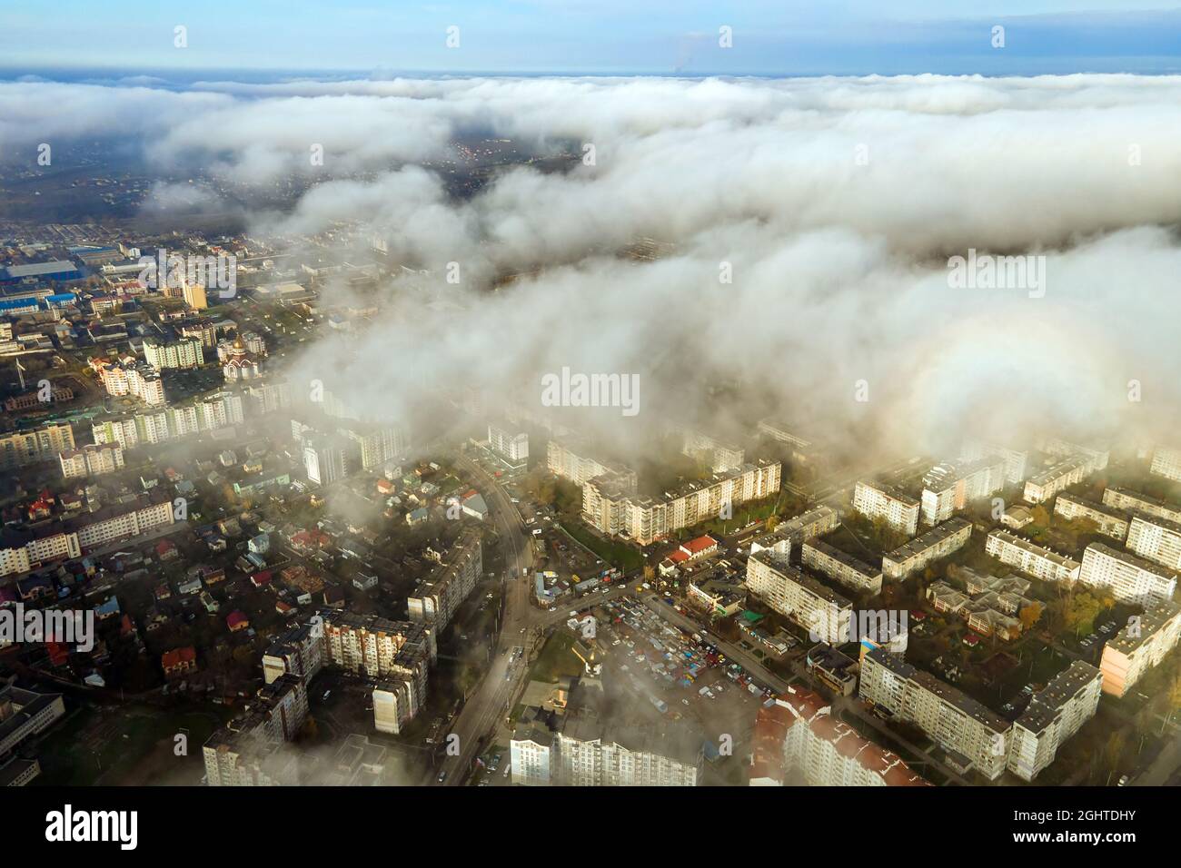Top aerial view of fluffy white clouds over modern city with high rise ...
