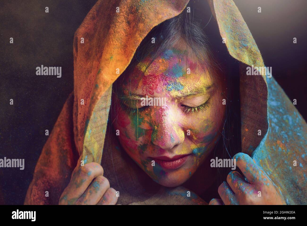 Portrait of an Indian Woman covered in multi coloured powder during Holi festival Stock Photo
