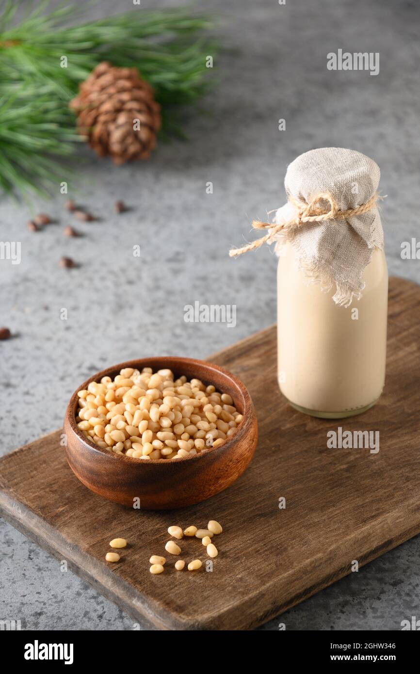 Vegan cedar nut milk in bottle on gray background. Non dairy alternative milk. Healthy vegetarian drink. Close up. Stock Photo