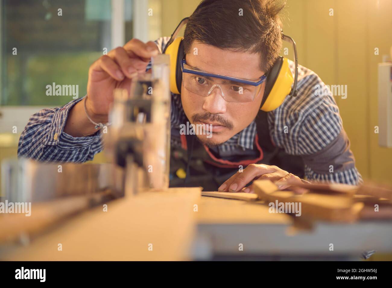 Portrait of a carpenter using a circular saw in a workshop, Thailand Stock Photo