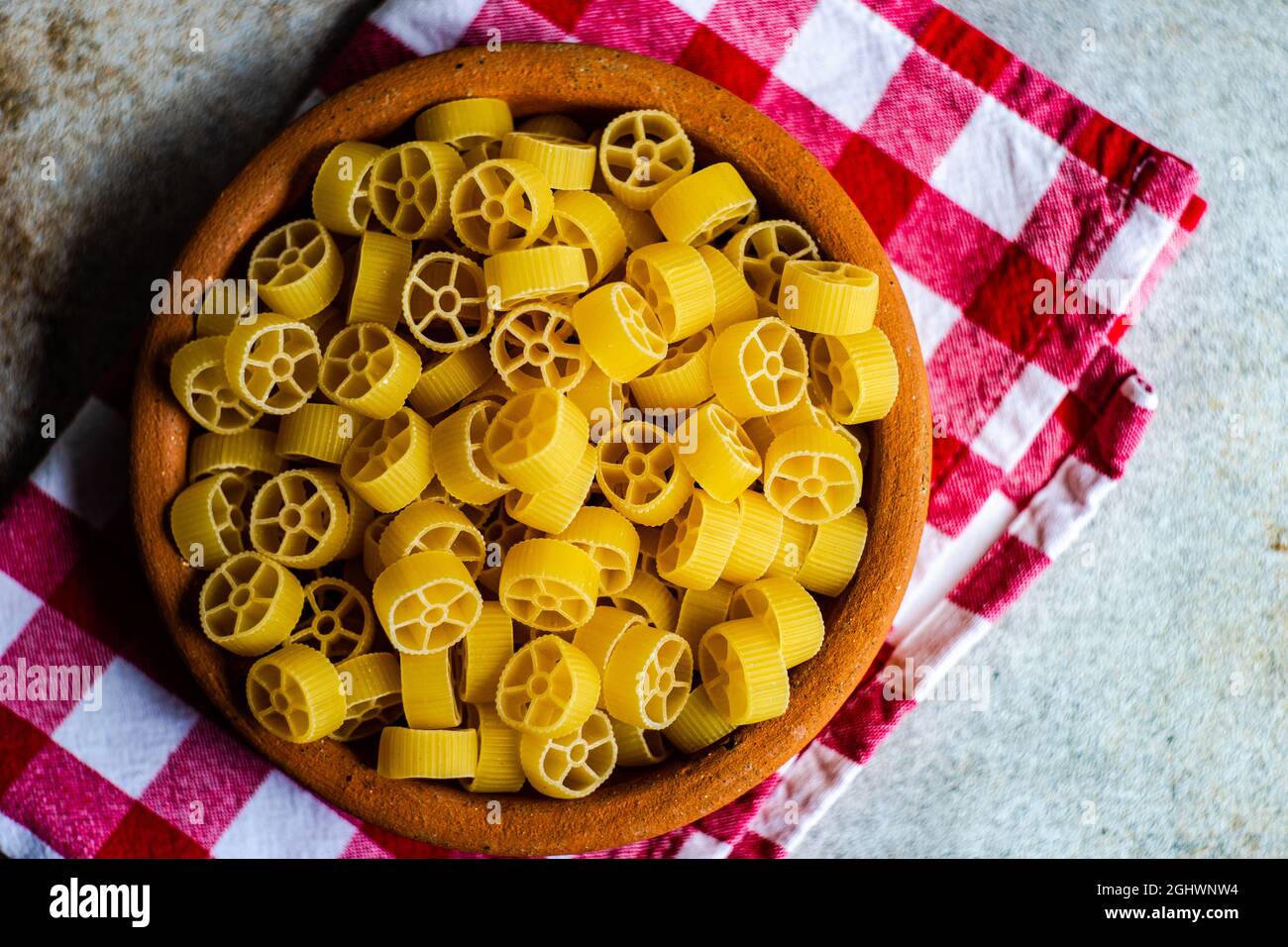 Overhead view of a bowl of ruote pasta on a folded napkin Stock Photo