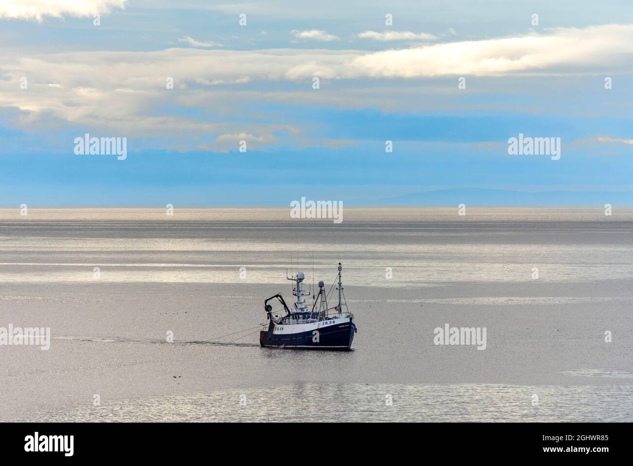 TRAWLER WITH NET FISHING FOR SQUID OFF THE MORAY COAST SCOTLAND ON A SUMMER EVENING Stock Photo