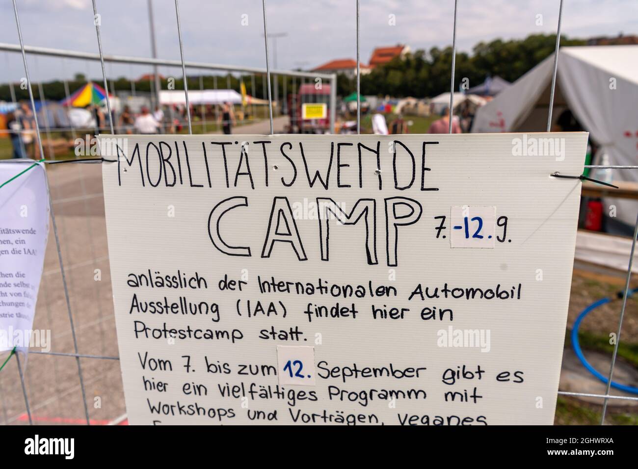 Munich, Germany. 07th Sep, 2021. A sign with the title 'Mobilitätswende Camp - 7.-12.9.' hangs on the fence of the camp, which is set up on the Tresienwiese. The IAA Mobility 2021 trade fair will take place in Munich from 7-12 September 2021. Credit: Peter Kneffel/dpa/Alamy Live News Stock Photo