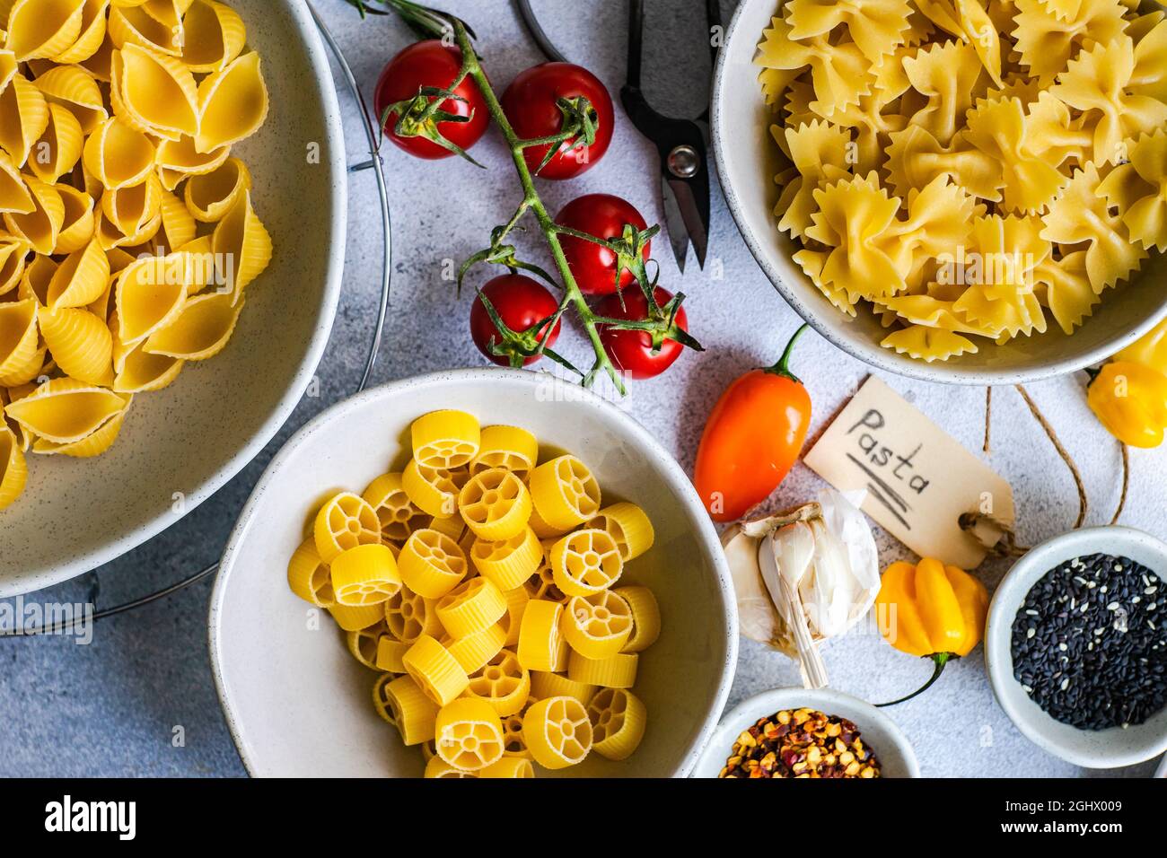 Raw pasta on a table with ingredients for making a sauce Stock Photo