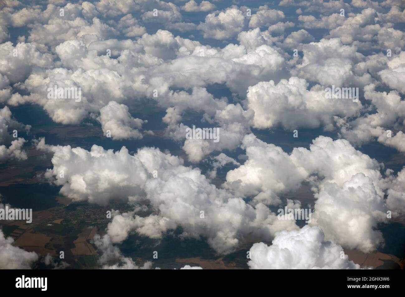 Aerial view from airplane window of white puffy clouds on bright sunny ...