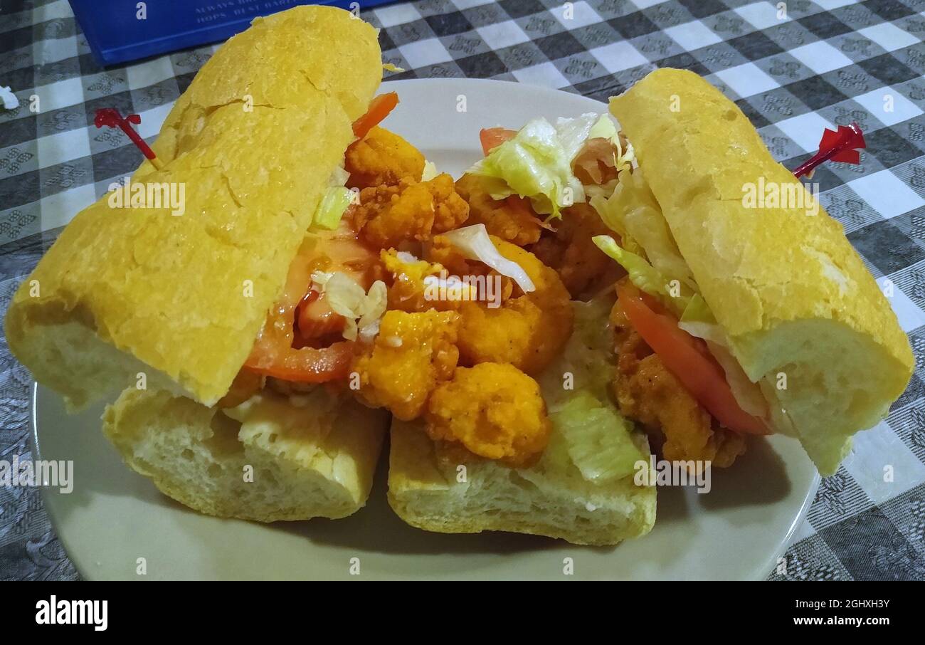 A shrimp po' boy sandwich dressed with lettuce and tomato is served at Thompson's Kitchen restaurant on Friday, July 16, 2021 in Port Sulphur, Plaquemines Parish, LA, USA. A traditional sandwich from Louisiana, po' boys are typically served on New Orleans French bread having a crisp crust and fluffy center. (Apex MediaWire Photo by Billy Suratt) Stock Photo