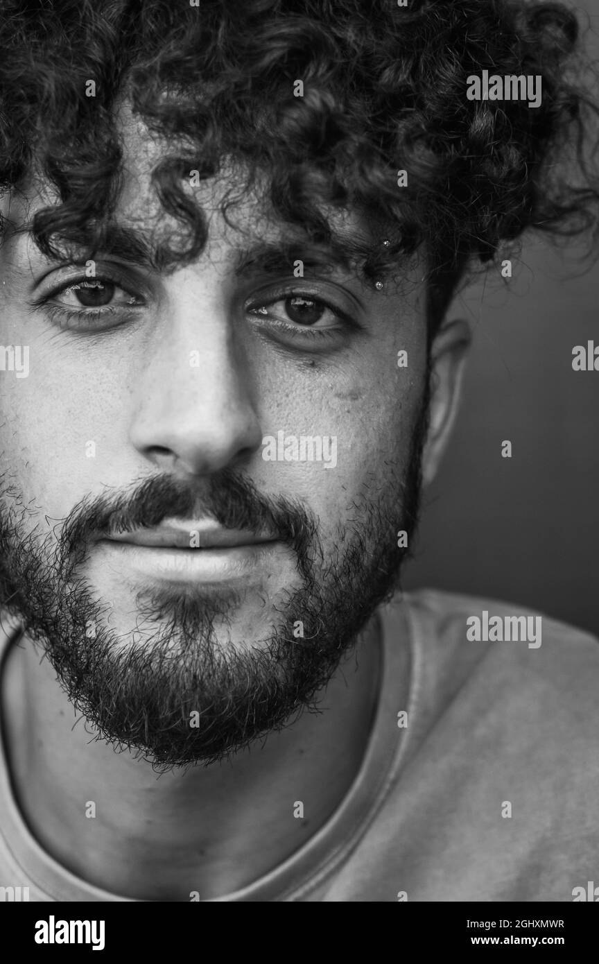 close up portrait in black and white of a young man with a beard and ...