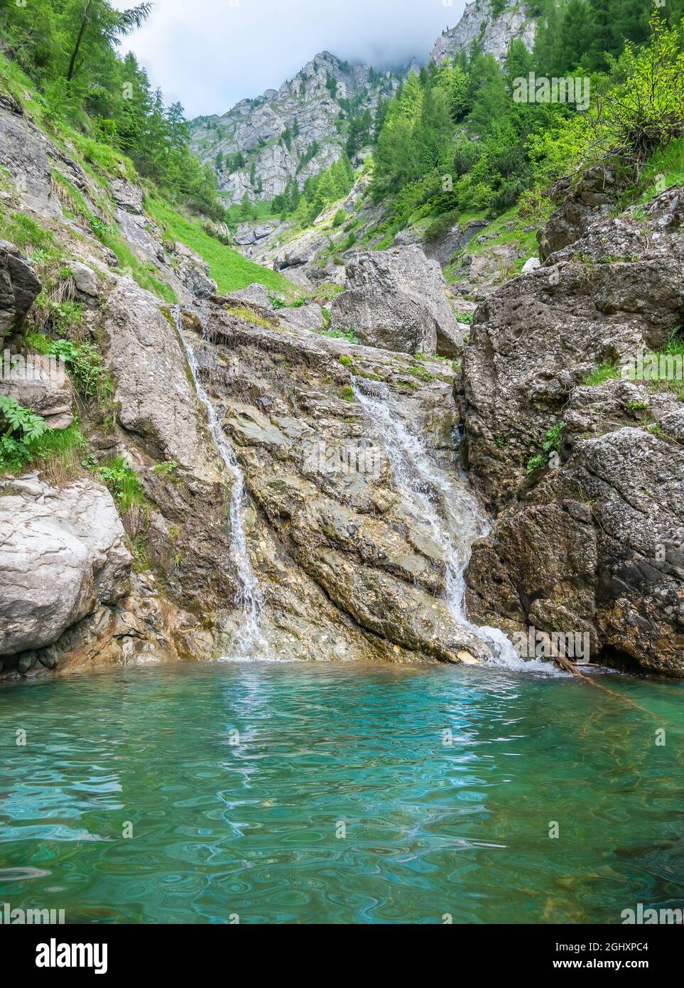 Small waterfall with the water flowing through the rock in a natural ...
