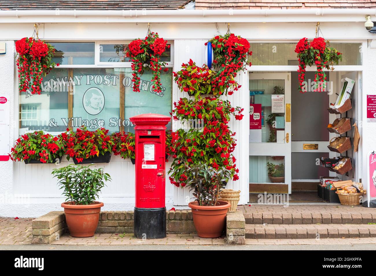 Exterior of Alloway post office and local shop with hanging baskets and
