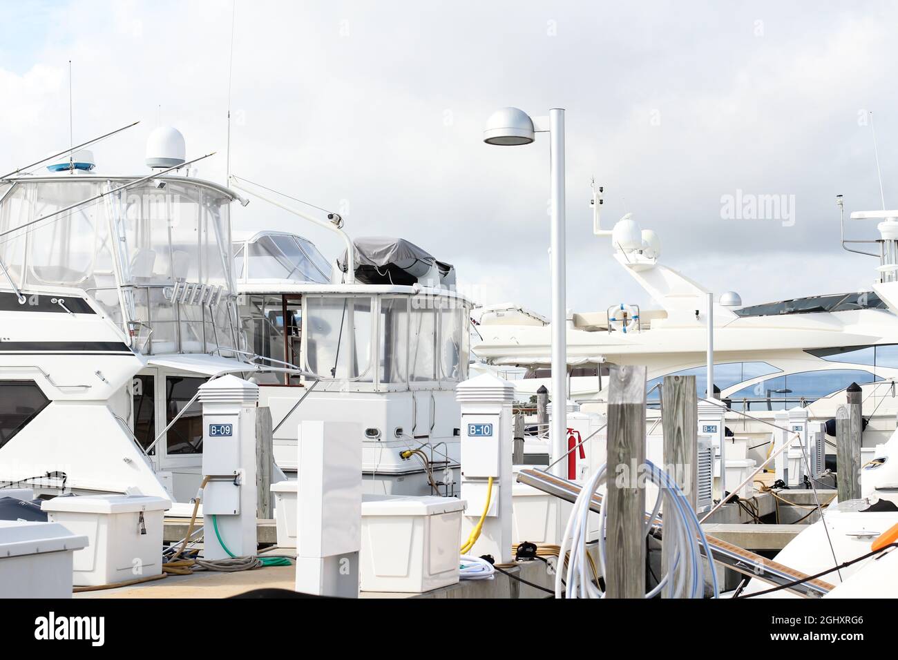 Beautiful white modern yachts parked at sea port dock. Yacht club, luxury boats Stock Photo