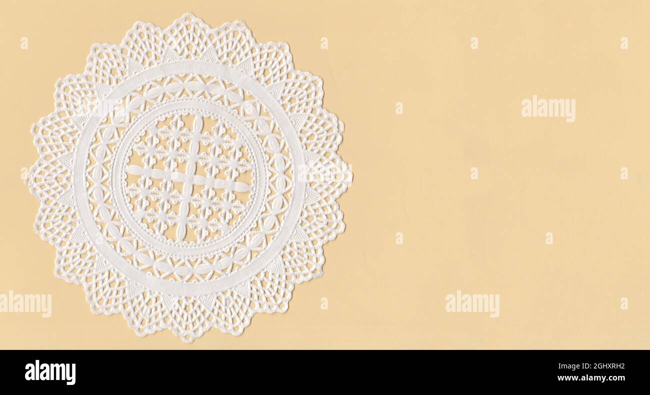 A paper Cup Cake Doily on top of a yellow paper. With empty space Stock Photo
