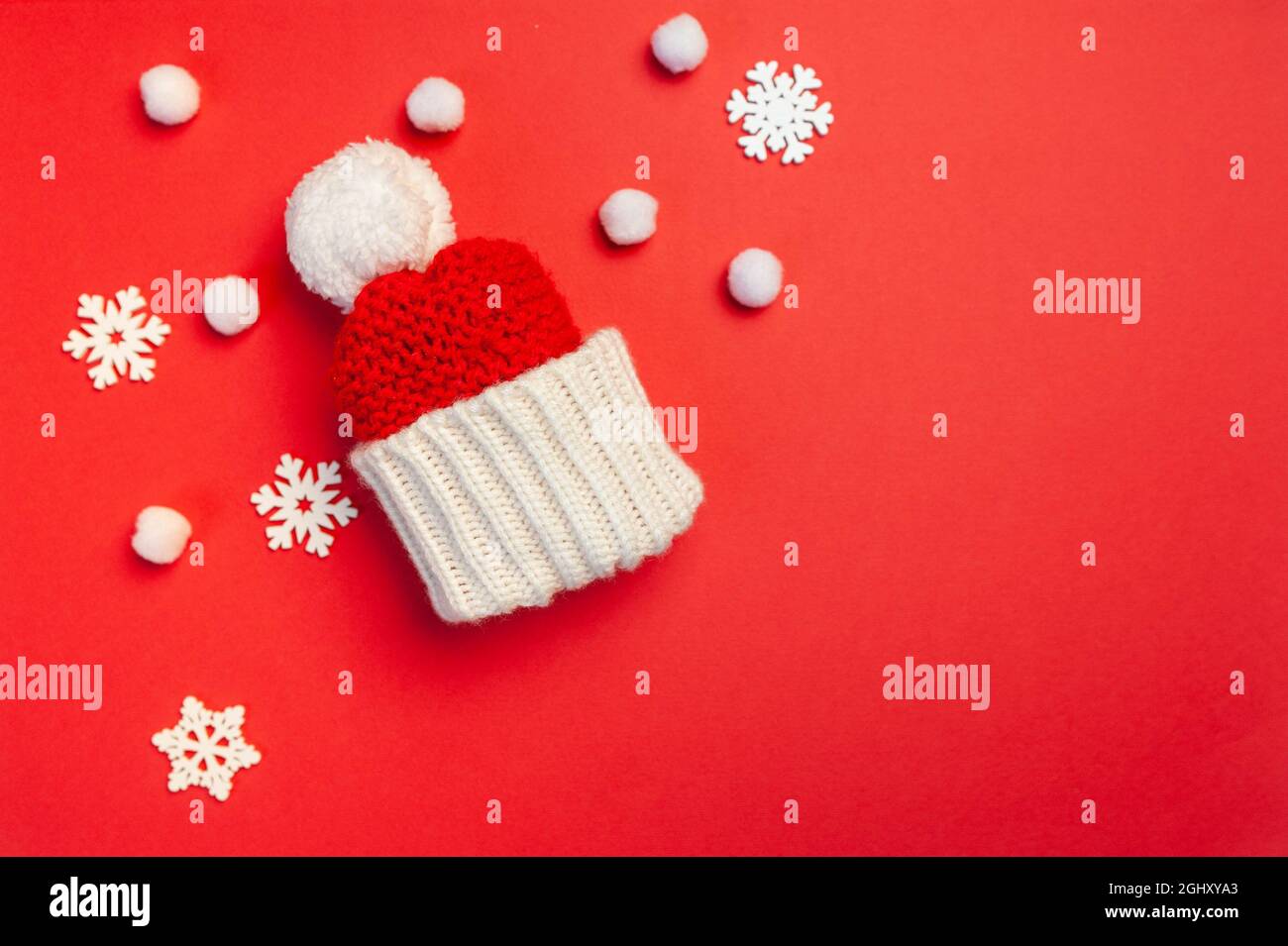 Christmas greeting card with red hat and snowflakes on red backgroun. Xmas holiday postcard with place for your text. Happy New Year winter Stock Photo