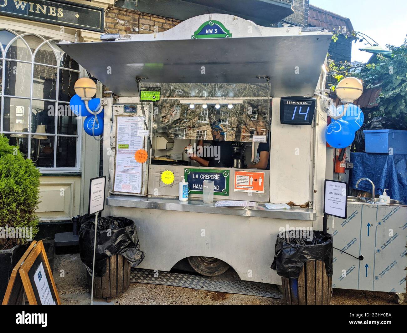 LONDON, UNITED KINGDOM - Feb 27, 2021: a crepe street food white stall with balloons and bins in front in London, united kingdom Stock Photo