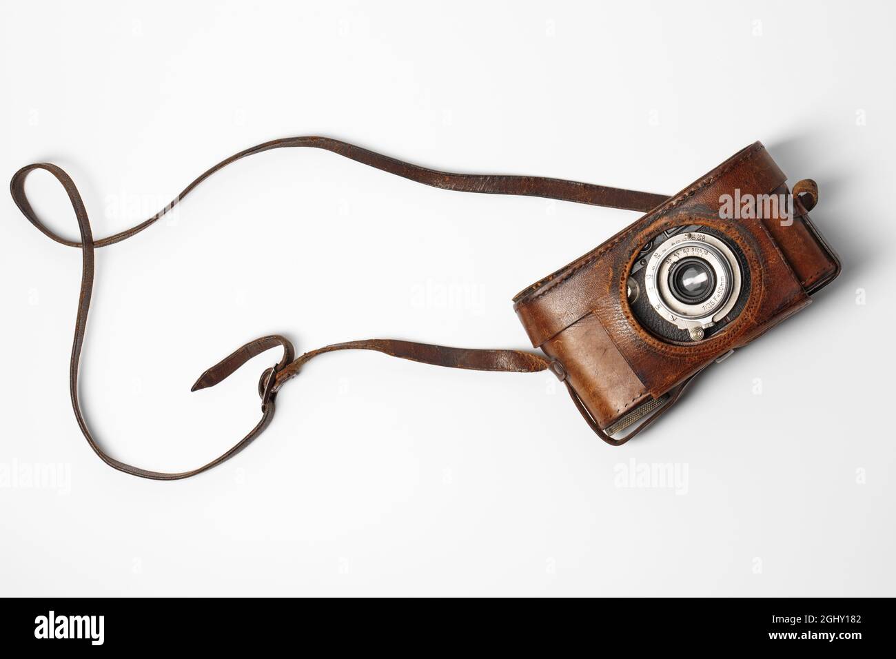 Old vintage camera with 35mm lens in brown leather case isolated on white background Stock Photo