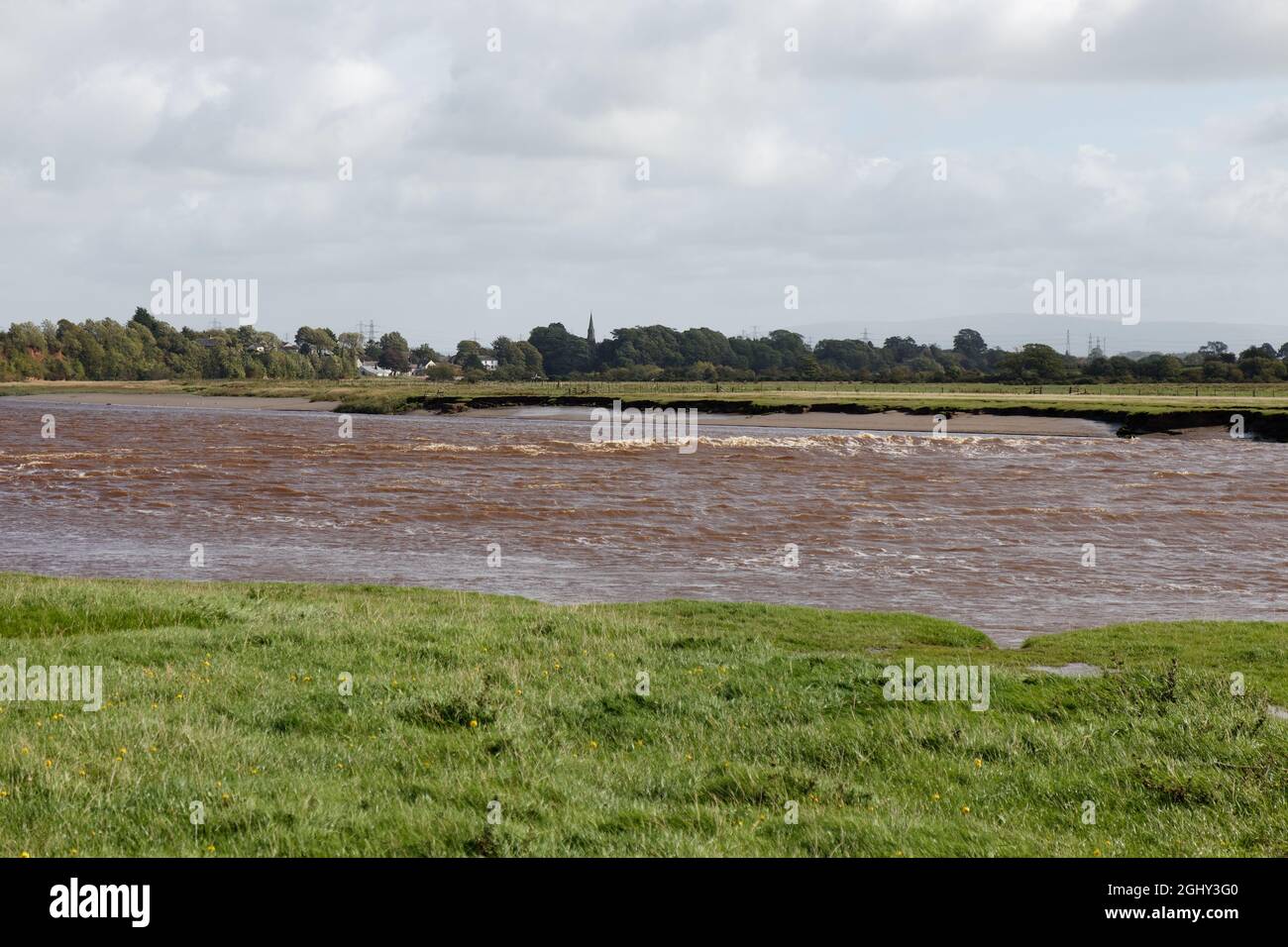 The Solway Bore in the channel of the River Eden with Rockcliffe village in the distance Stock Photo