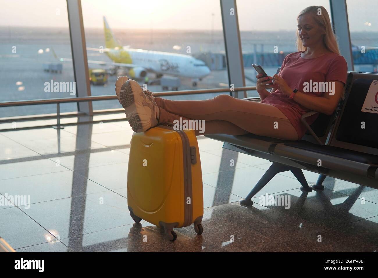 yellow suitcase to the airport near the luggage belt. Stock Photo