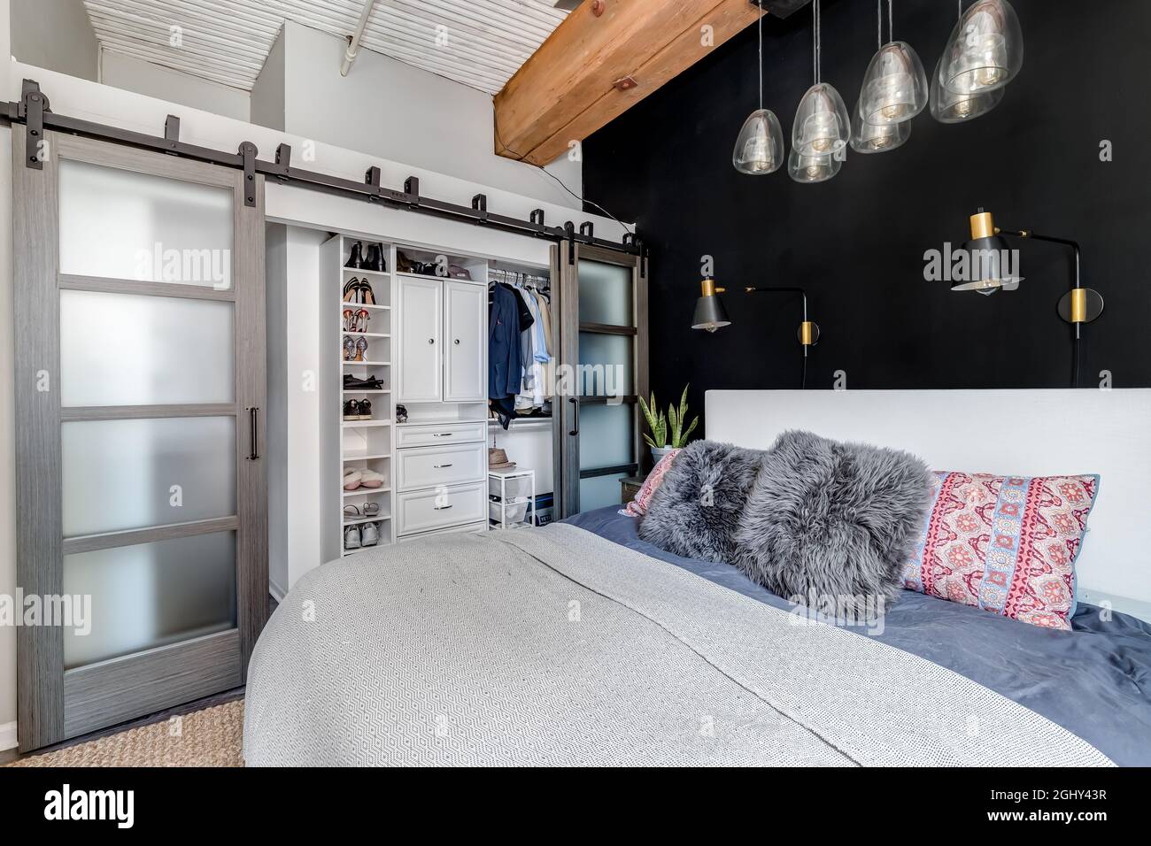 Picture of A bedroom in a loft condo with an exposed wood ceiling, glass sliding ...