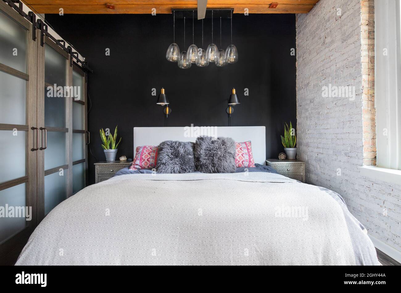 Picture of A bedroom in a loft condo with an exposed wood ceiling, glass sliding ...
