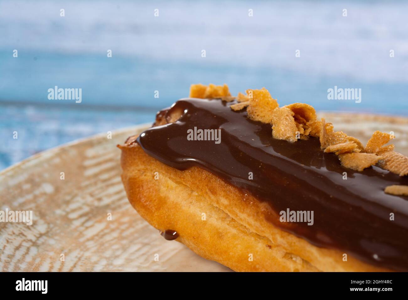 Chocolate eclair with coffee beans on light blue background isolated Stock Photo