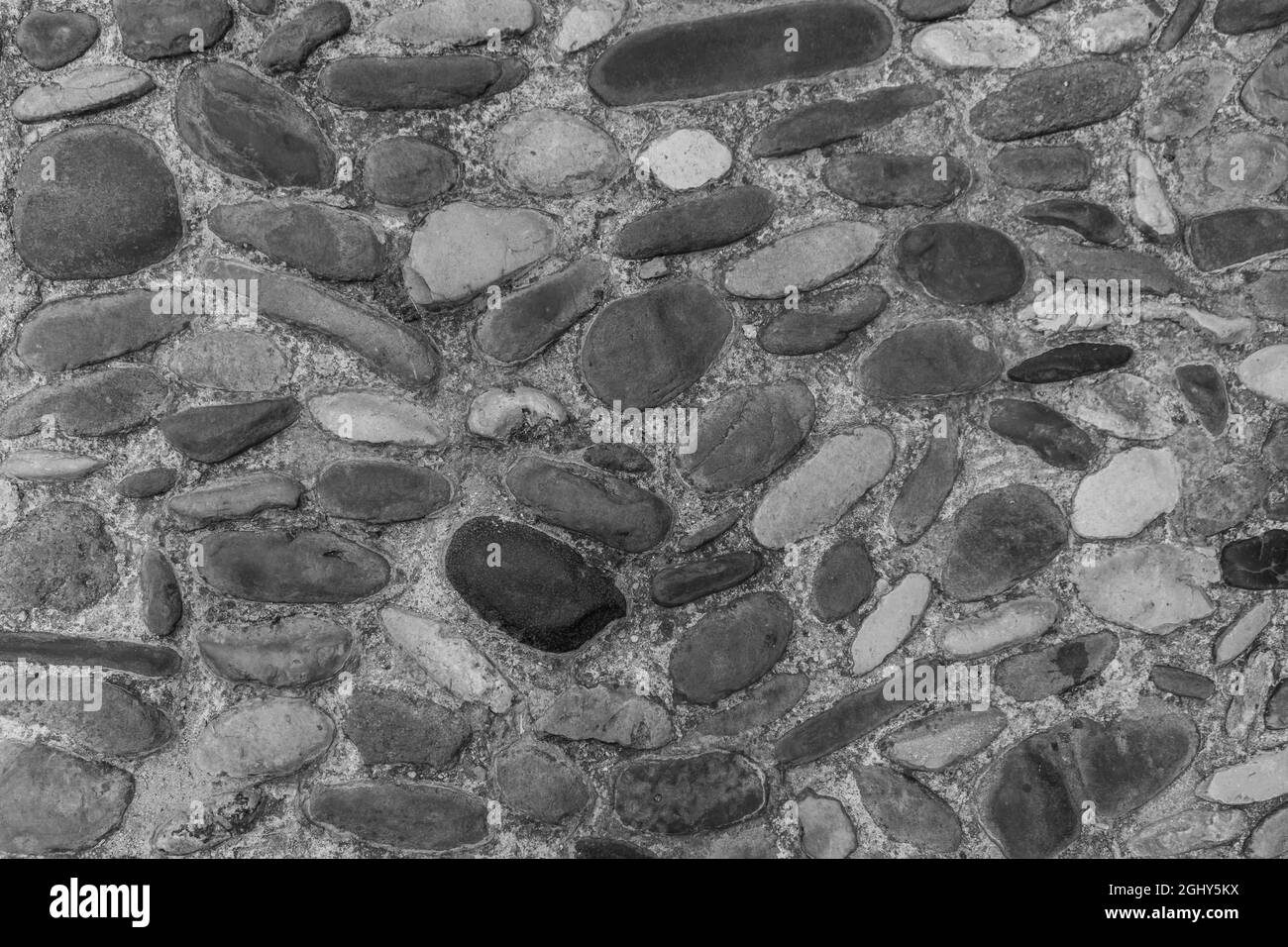 Texture of stone wall background.Old medieval street cobblestone pavement.Black and white photography Stock Photo