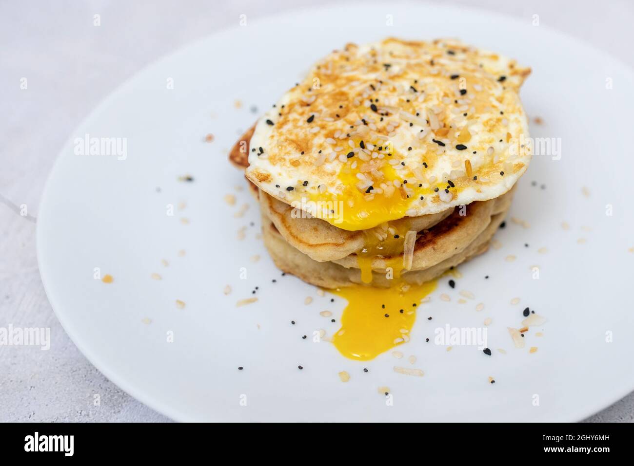 Protein pancakes with fried egg and bagel seasoning. food for calorie controlled diet. Stock Photo