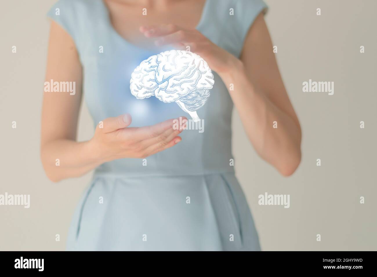Unrecognizable female patient in blue clothes, highlighted handrawn brain in hands. Human nervous system issues concept. Stock Photo