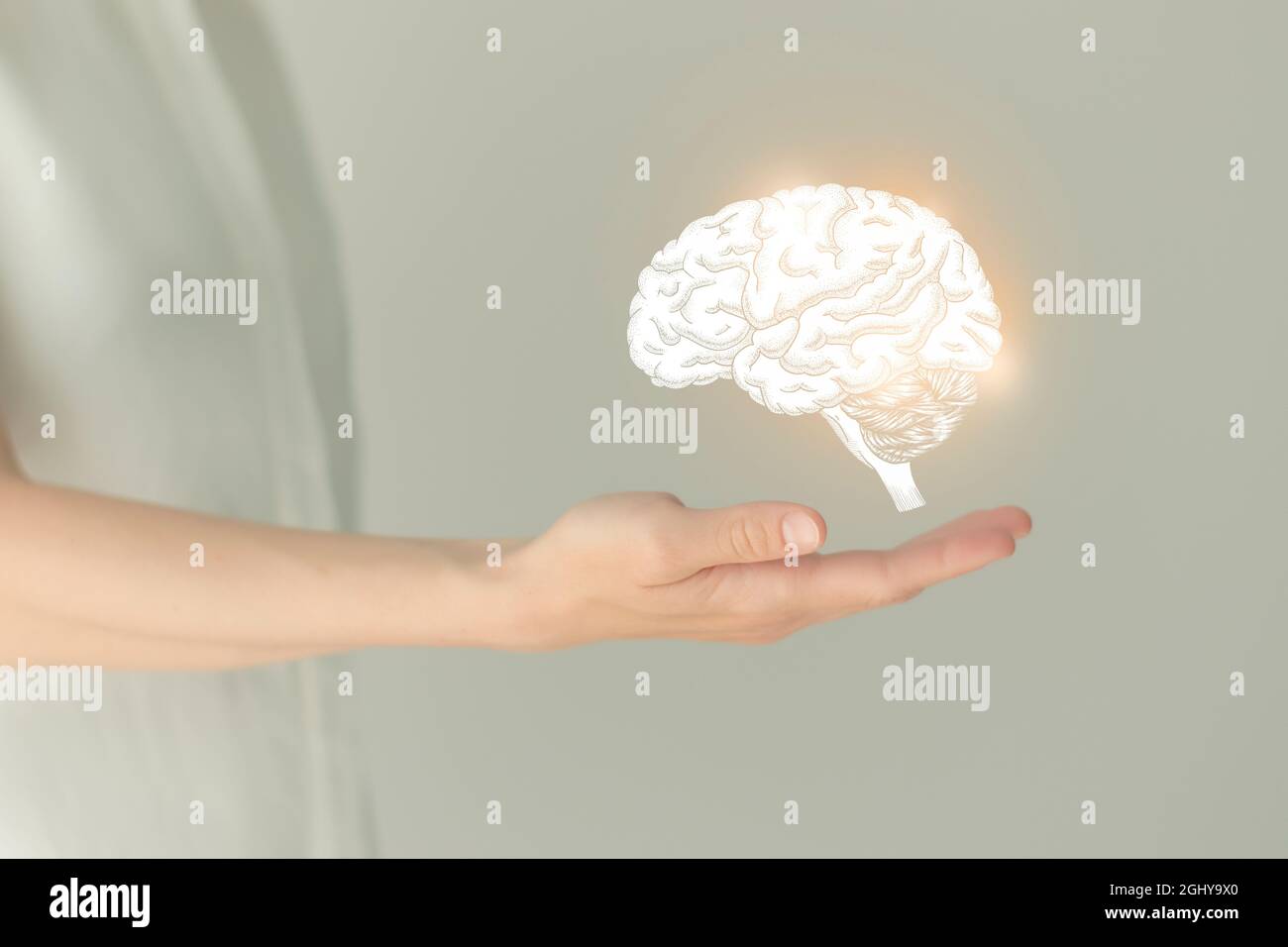 Unrecognizable female patient in white clothes, highlighted handrawn brain in hands. Human nervous system issues concept. Stock Photo
