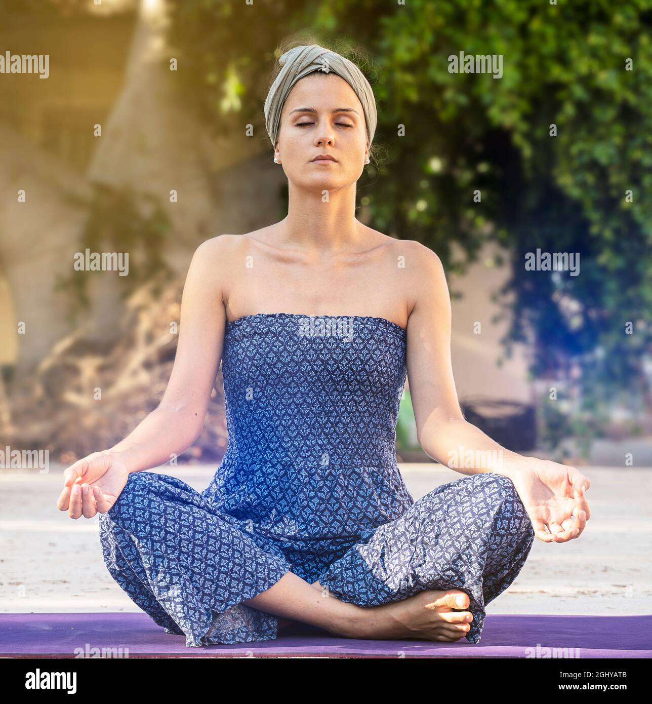 square photo of a young woman outdoors. meditation position, eyes closed and legs crossed. practice yoga Stock Photo