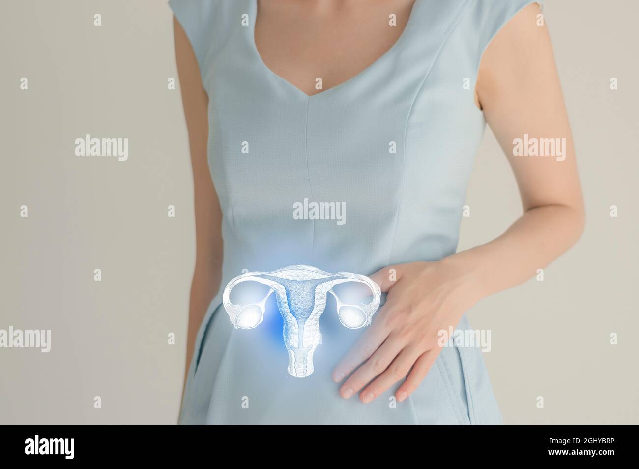 Unrecognizable female patient in blue clothes, highlighted handrawn uterus in hands. Human reproductive system issues concept. Stock Photo