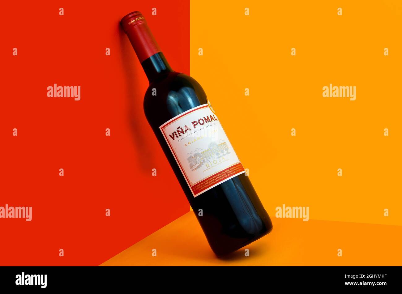 Bottle of wine tilted, with background colors (red, orange Stock Photo