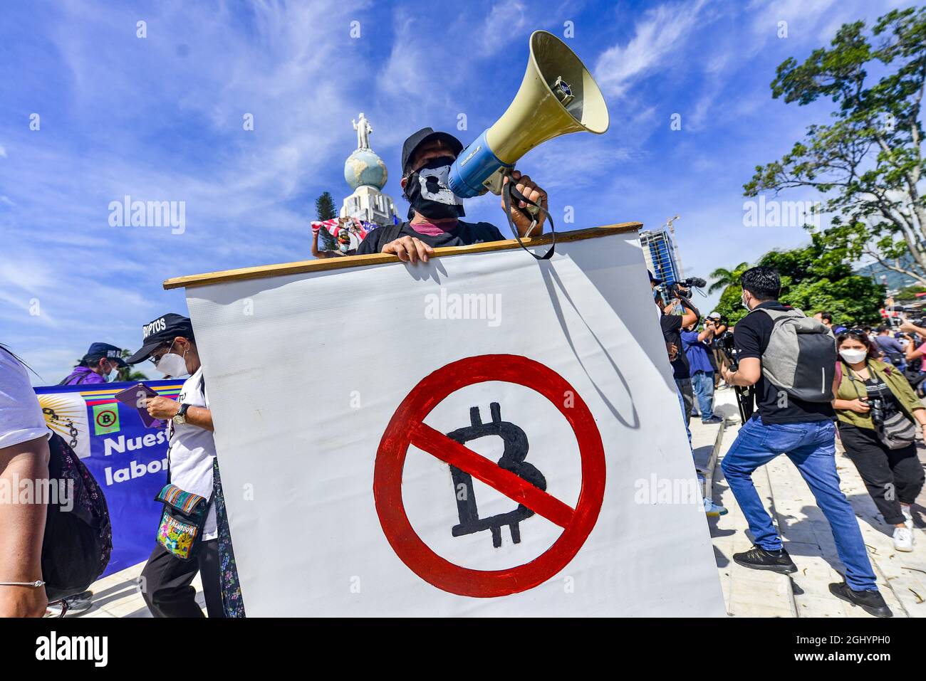 San Salvador, El Salvador. 07th Sep, 2021. A demonstrator holds an anti- bitcoin banner while chanting anti-government slogans on a megaphone during  the protest march. Thousands of Salvadorans took to the street to