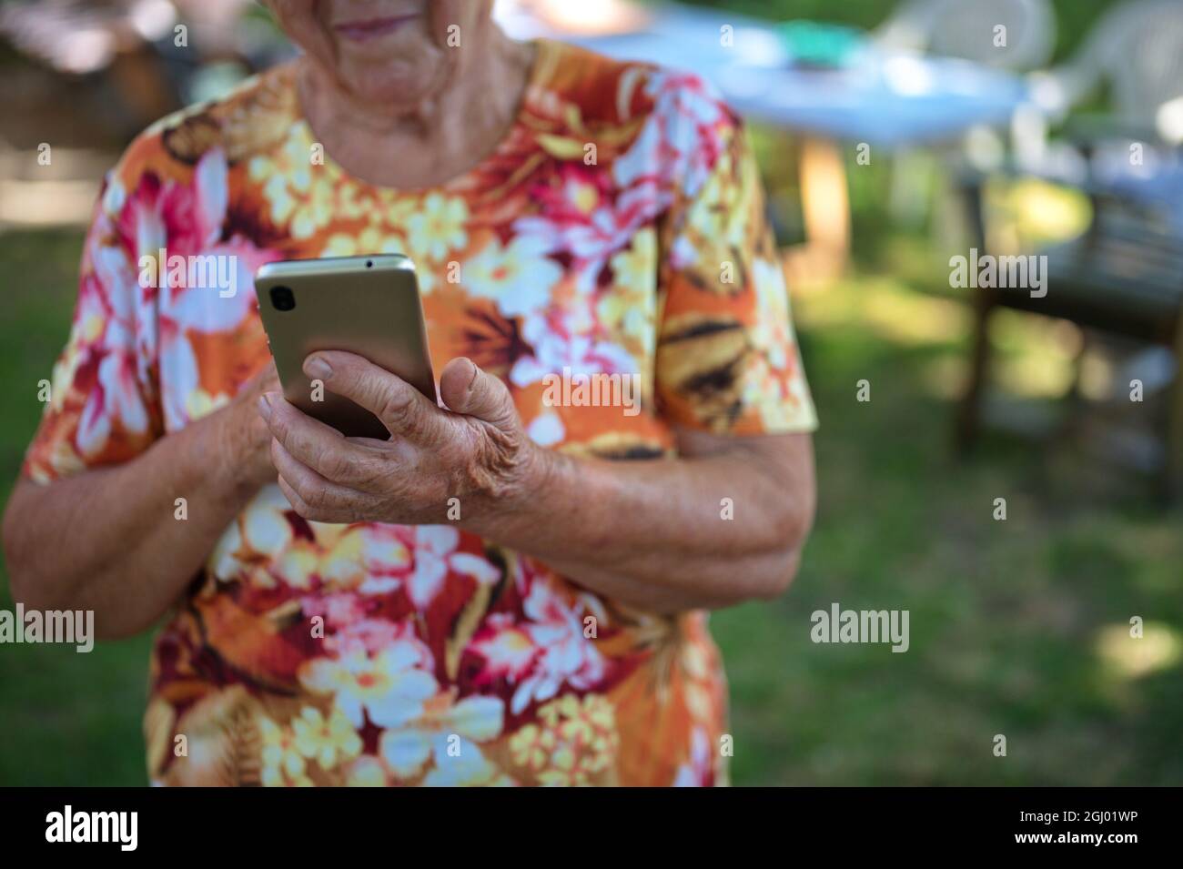 Midsection of senior woman using mobile phone Stock Photo