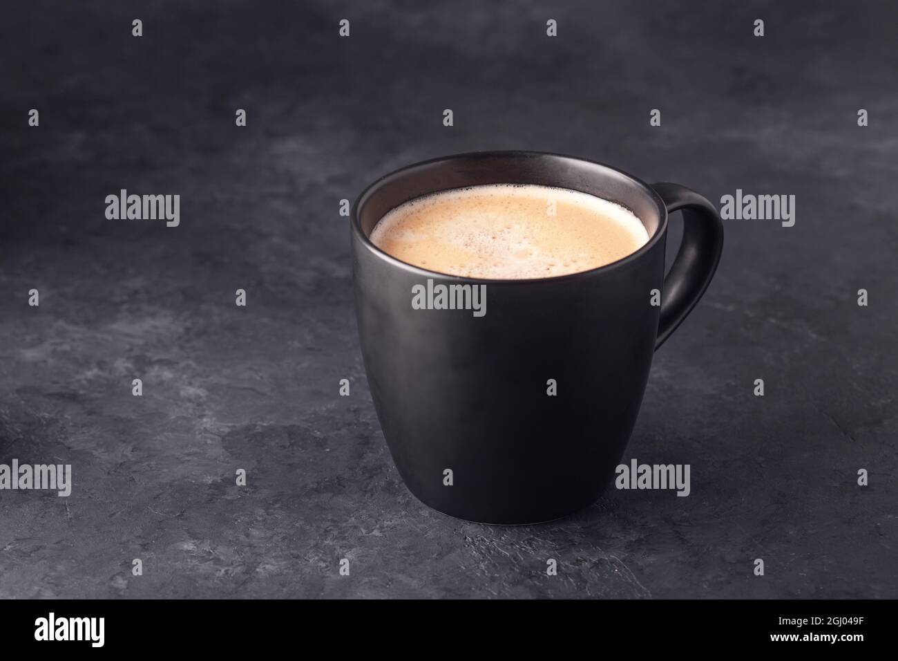 Balck ceramic mug of fresh hot coffee on on dark stone background. Copy space for your text - Image Stock Photo