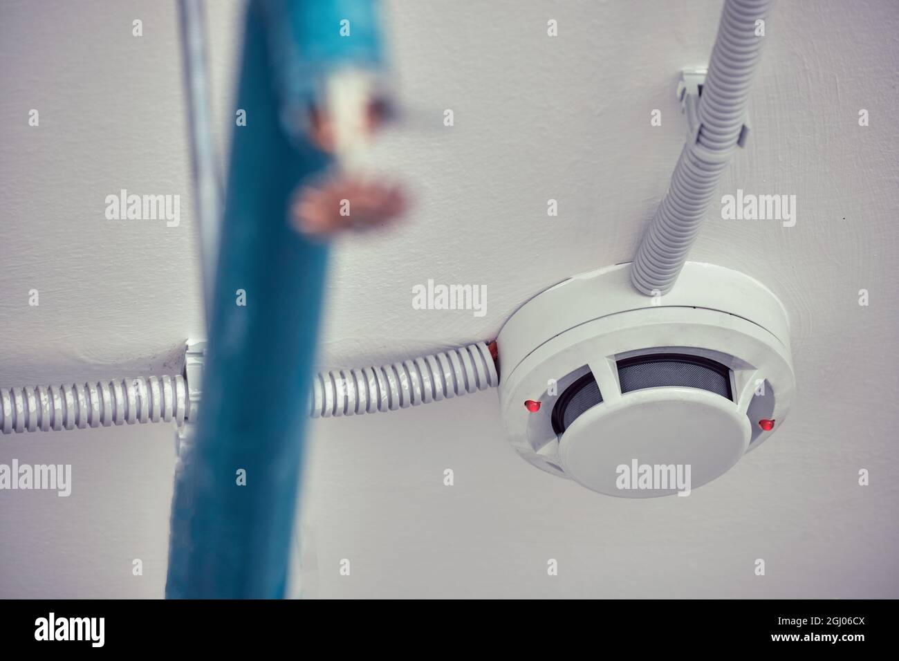 Flashing red lights fire alarm system on the ceiling in the room building. Smoke detector fire
