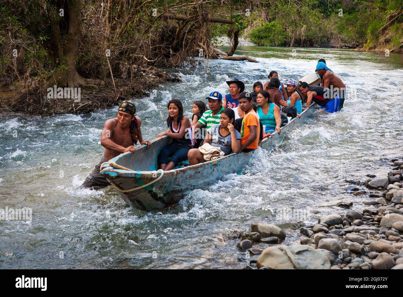 Panamanian people traveling downstream Rio Pequeni in a boat, Chagres national park, Republic of Panama, Central America. Stock Photo