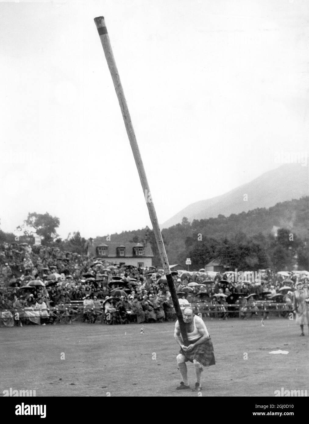 A crowd of 20,000 including many overseas visitors welcomed the Queen and Duke of Edinburgh at the Braemar Gathering in Scotland for the Games. F. Reid is Tossing the Caber. 10th September 1954 Stock Photo