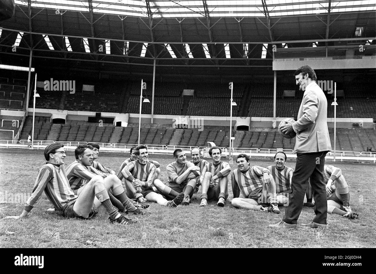 Jimmy Hill ex-manager of Coventry City and now head of sport for Weekend Television, briefs his team of commentators and others involved in the production of the company's sports programme at Wembley Stadium, when they exchanged their usual roles off the field for a game on the famous turf. London - 30th July 1968. Stock Photo