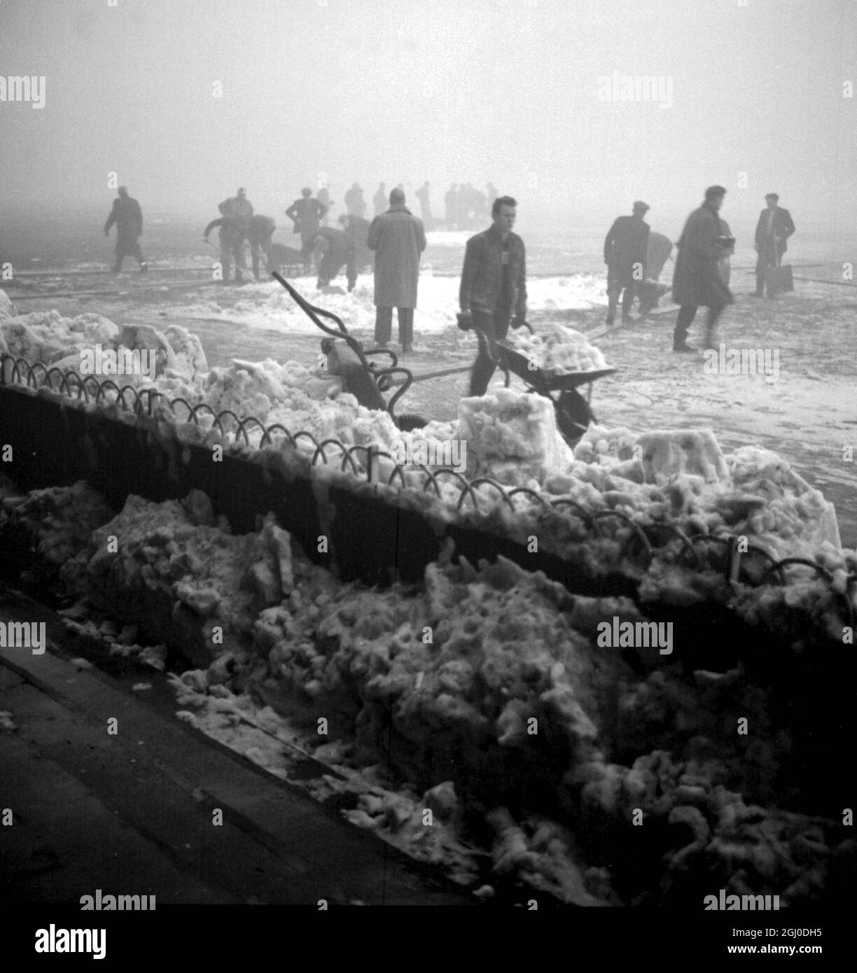 Groundsmen are seen hard at work clearing snow from the pitch at Tottenham Hotspurs ground White Hart Lane. Their efforts unfortunately were in vain as the referee Jack Sturgeon declared that the FA Cup third round match between the London club and Burnley would not take place. 4th January 1963. Stock Photo