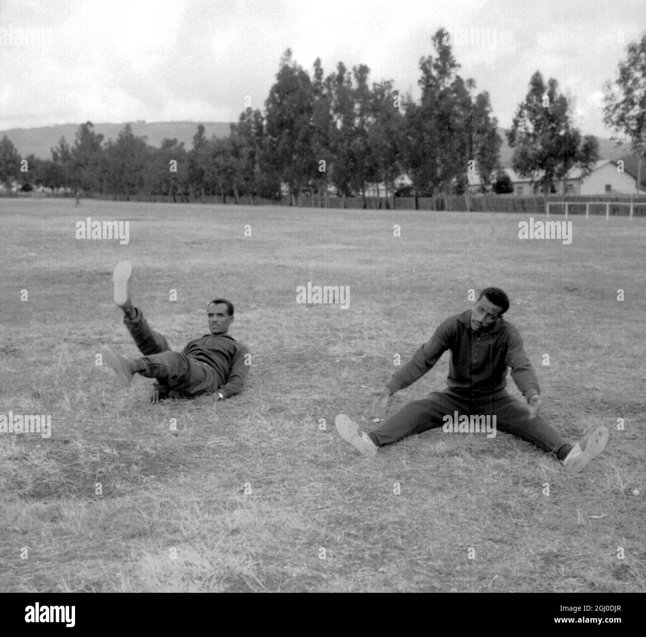 Olympic games marathon winner of the Rome, 1960 games, Ethiopia's Abebe Bikila (right) is pictured undergoing physical training exercises in Addis Ababa, Ethiopia. With him is Mamo Wolde. They are training for next years Olympic Games which will be staged in Tokyo. 5th December 1963. Stock Photo
