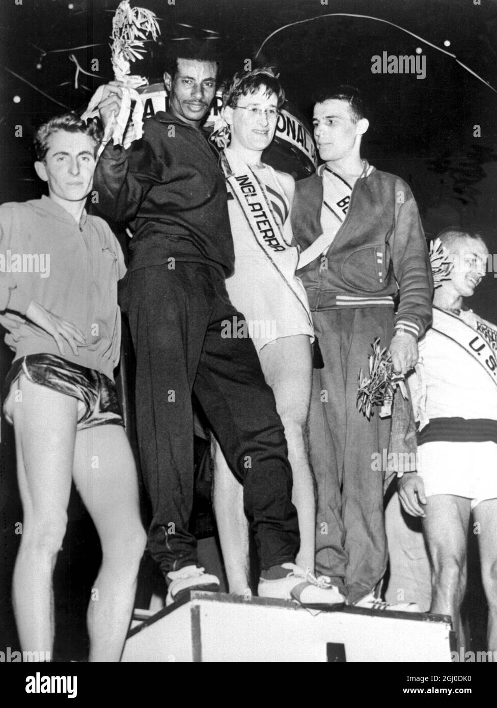 England's Martin Hyman (centre) the winner is flanked by second-place winner Abebe Bikila (left) of Ethopia after victory in the 7.4 kilometre Sao Silvester race. Sau Paulo, USA. 31st December 1961. Stock Photo